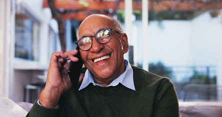 Lachende oudere man aan de telefoon