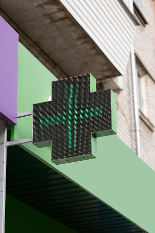 Groen apotheekkruis op een gevel