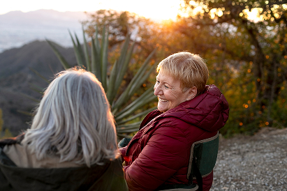 Twee oudere vrouwen zitten buiten in de natuur
