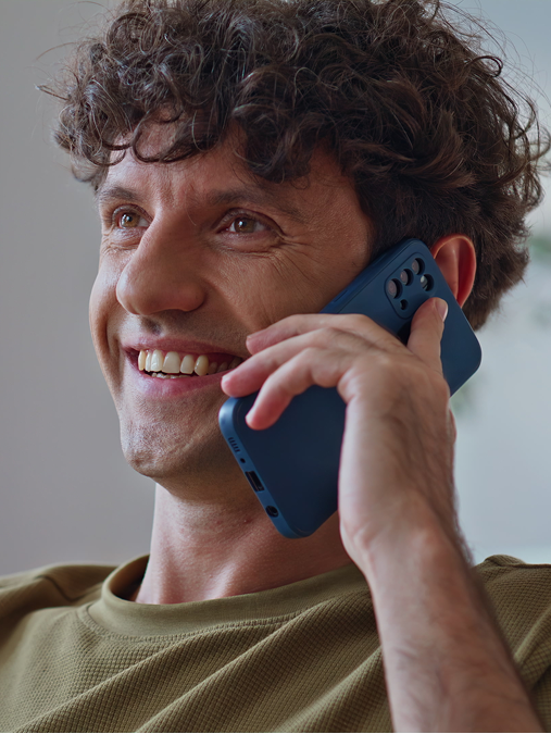 Lachende man aan de telefoon thuis op de bank