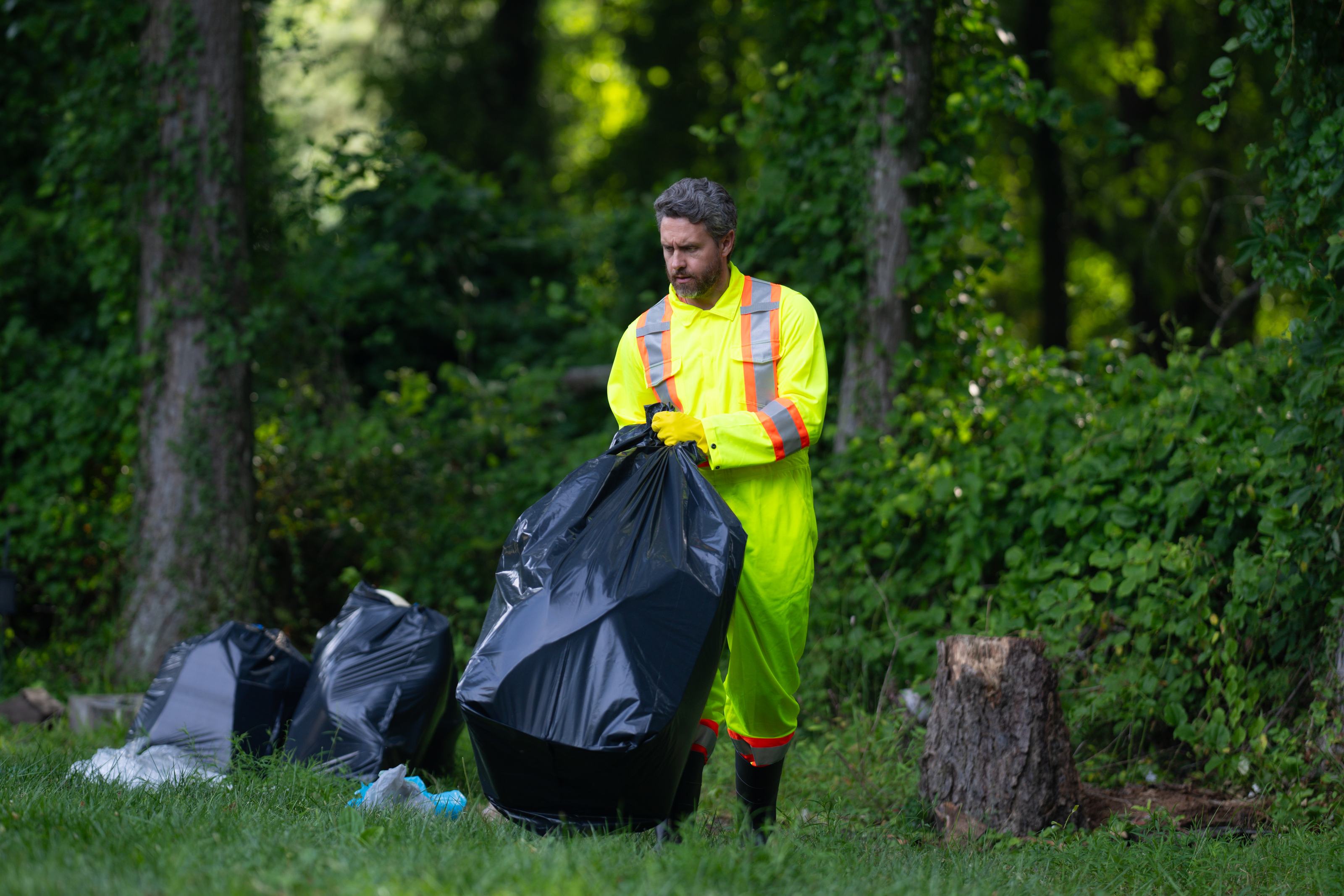 Gemeentemedewerker ruimt afval op in het park