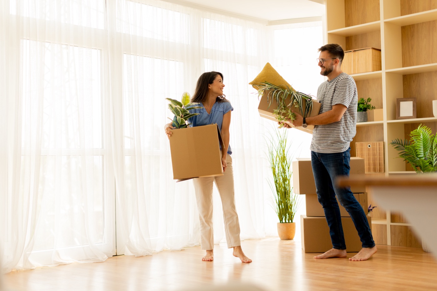 Stel draagt dozen een nieuw appartement in
